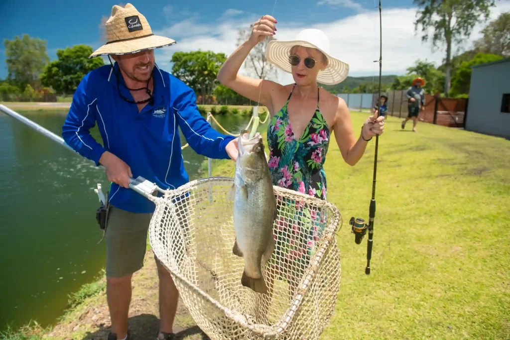 Accessible fishing instructor with woman holding rod
